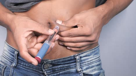 hombre inyectándose insulina en el abdomen