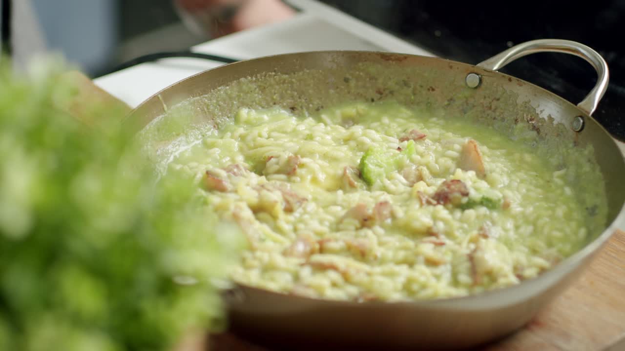 cocinero de cultivos mezclando risotto caliente en una sartén