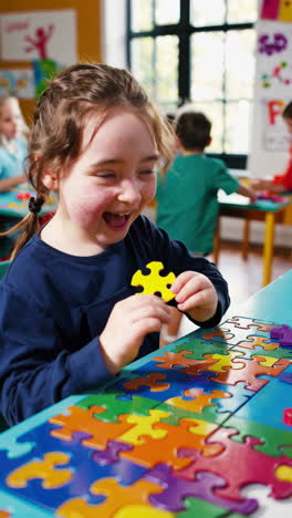 a young child playing with a colorful jigsaw puzzle in a classroom
