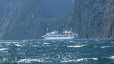 spectacular passage: massive ferry cruises past a milford sound waterfall in captivating stock footage