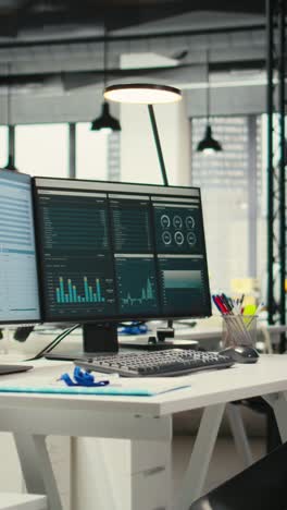 vertical video empty corporate workstations with computers running financial diagnostics