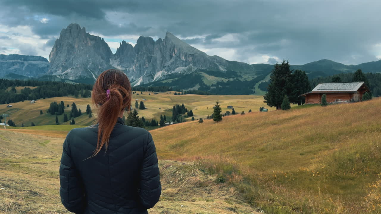 Video al rallentatore di una donna che ammira il paesaggio montano dell'Alpe di Siusi nelle Dolomiti, Italia