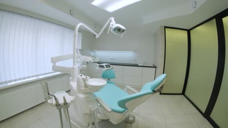 práctica dental moderna. silla dental y otros accesorios utilizados por los dentistas en azul, luz médica.