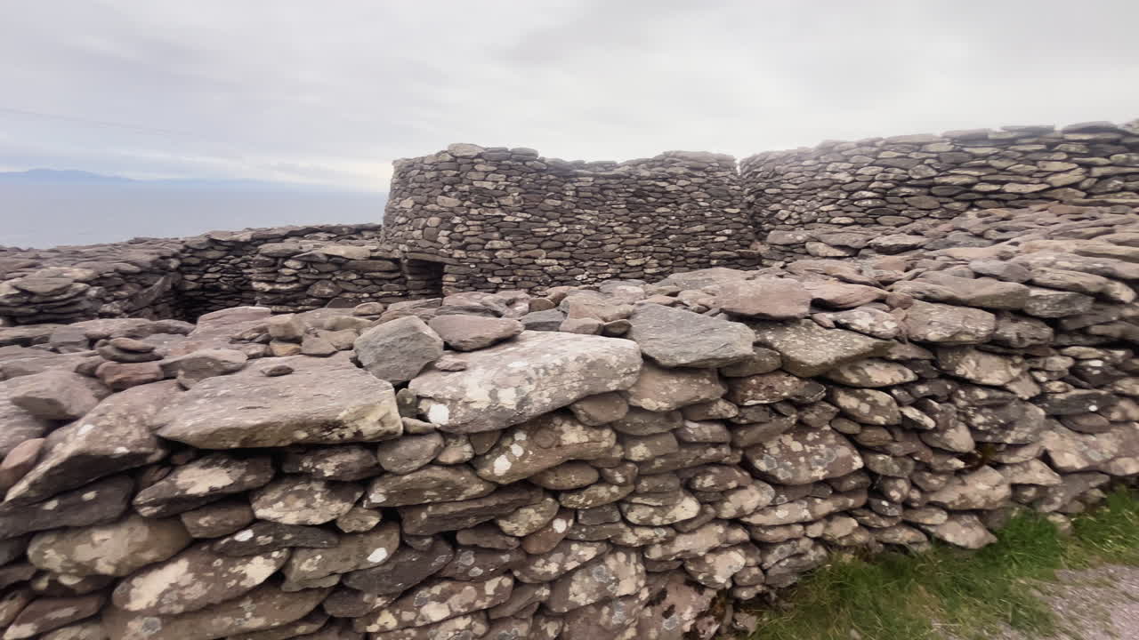 Panning cinematic shot of an ancient castle made of stones in Conor Pass, Ireland