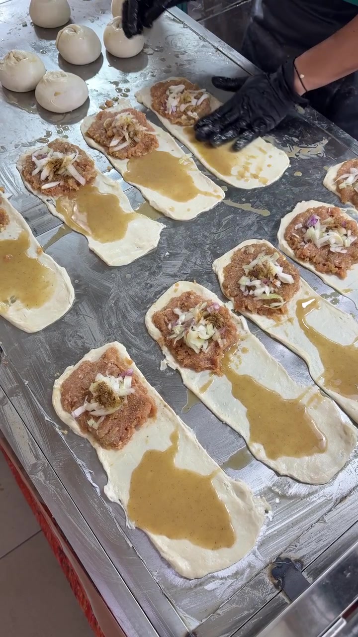 Chef Preparing Traditional Stuffed Dough Pastries in Commercial Kitchen