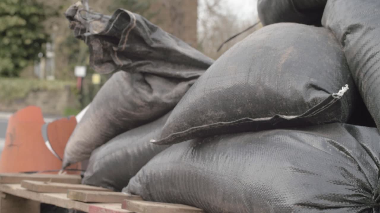 Pile of sandbags on pallets tilting shot