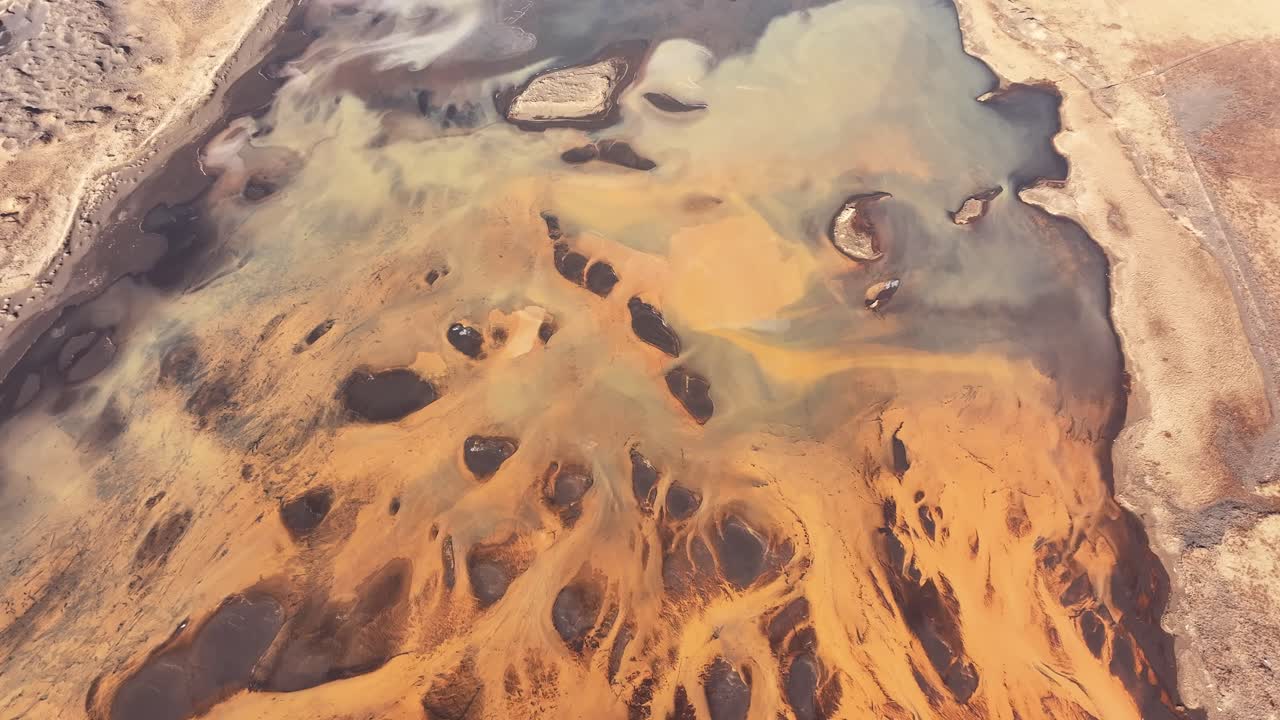 Aerial - golden Thjorsa River delta with swirling sediments in Iceland
