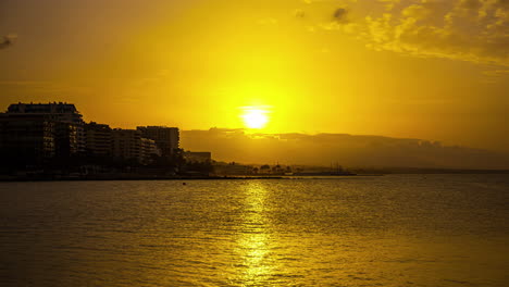 Durante-La-Puesta-De-Sol,-La-Ciudad-Sirve-Como-Un-Impresionante-Telón-De-Fondo-Para-Ofrecer-La-Vista-Más-Panorámica-De-La-Hermosa-Playa-De-Málaga-En-España.