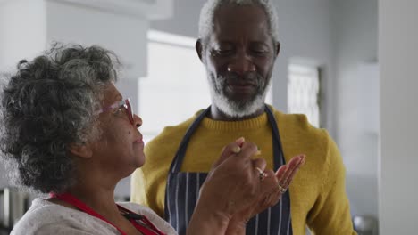 una pareja mayor afroamericana cocinando en casa. distanciamiento social en cuarentena