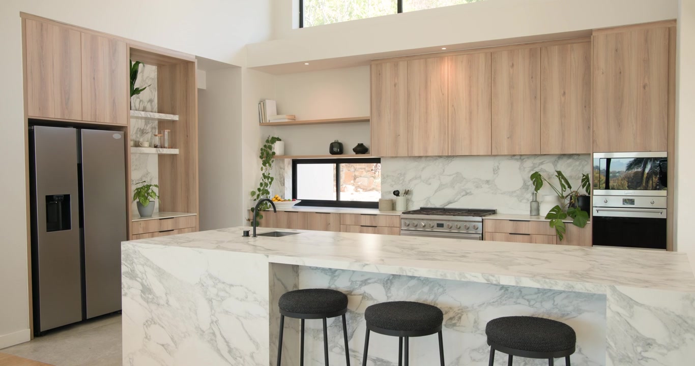 Kamera bergerak mundur dan mendongak, memperlihatkan meja dapur marmer dengan 3 bangku, menunjukkan tata letak dapur.