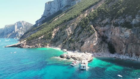 ferry boats at cala mariolu beach in sardinia, italy