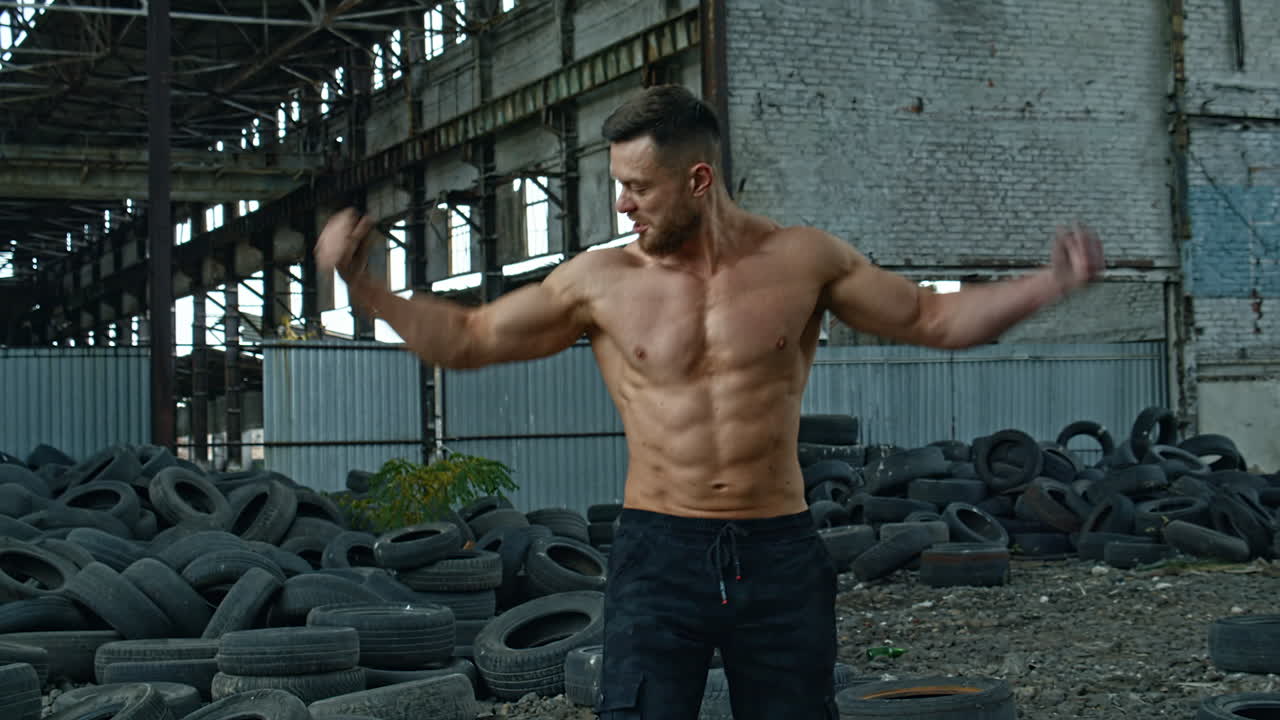 Shirtless bodybuilder posing outdoor. Handsome muscular model posing outdoors