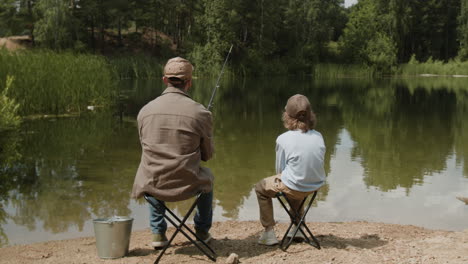 father and son fishing by the lake