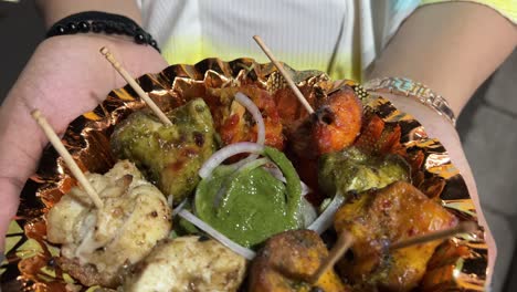 Profile-view-of-different-type-of-chicken-kebabs-served-on-plate-by-roadside-stall-in-Kolkata,-India