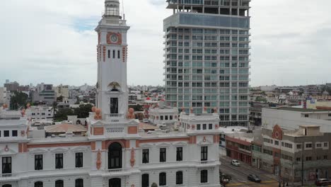 a clock tower, faro venustiano carranza stands as a historic marker beside modern high-rises in a veracruz, mexico