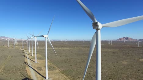 a high angle stationary aerial over a mojave desert wind farm as it generates clean energy for california