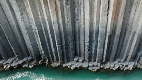 canyon of basalt columns, cliff with turquoise river, in iceland, aerial shot