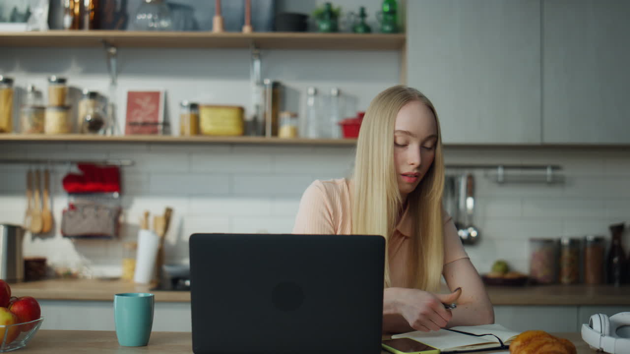 Freelancerin belegt Online-Kurse am Laptop und macht Notizen, Nahaufnahme. Mädchen arbeitet.
