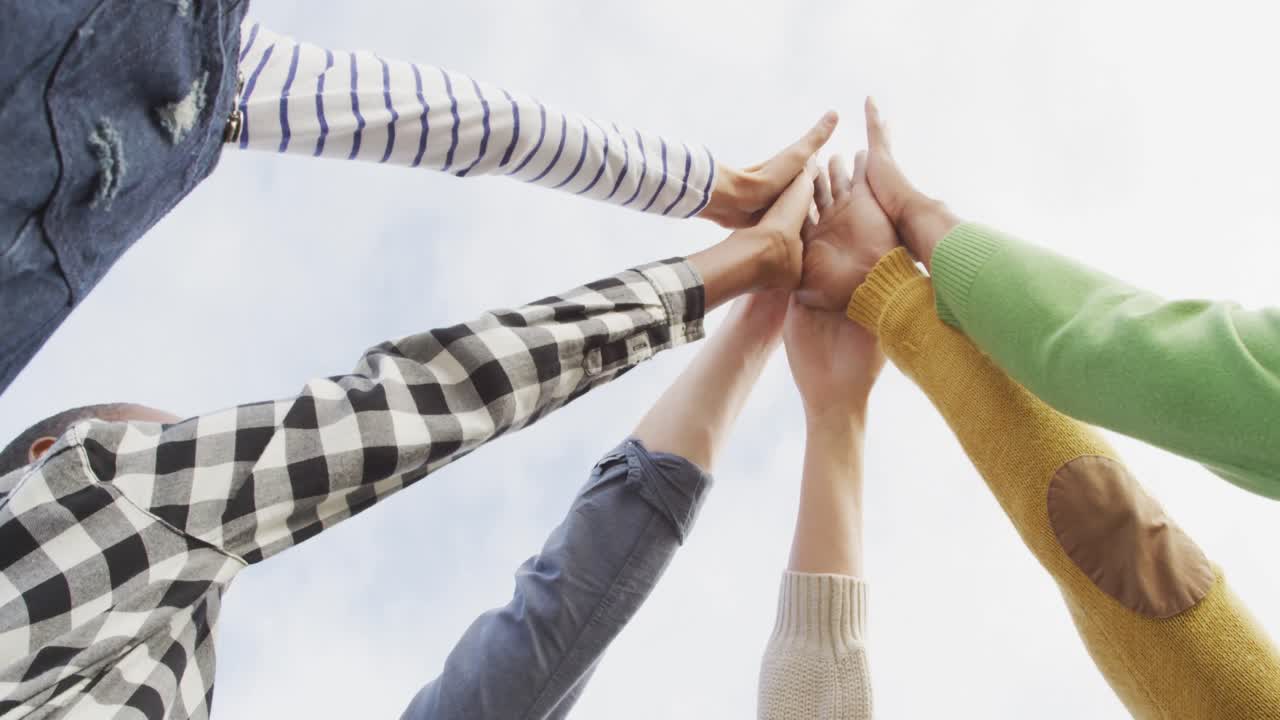 다양한 남성과 여성 비즈니스 동료들이 사무실에서 손을  ⁇ 고 동기를 부여합니다.