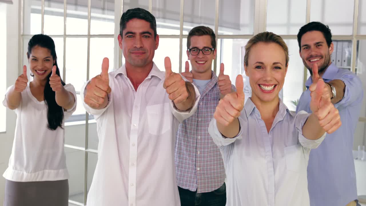 Team of creative designers showing thumbs up