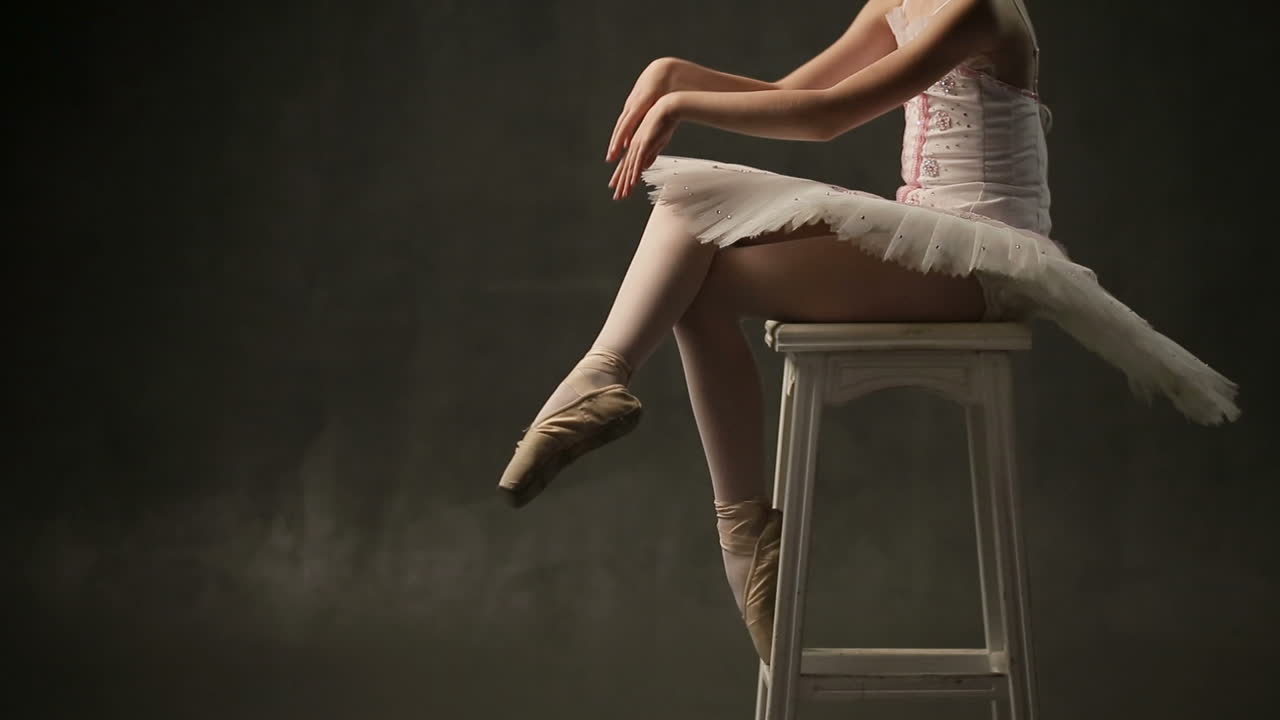 Young Ballerina Posing In Studio. Young beautiful girl ballerina against studio background