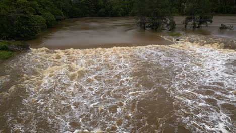Coomera, Gold Coast, 2 January 2024 - Rising aerial view of Coomera River Causeway under flood waters from the 2024 Storms in January