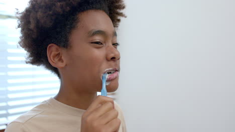 african american boy brushing teeth in bathroom, slow motion