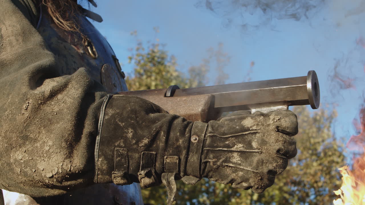 стрельба из старинного средневекового ручного огнестрельного оружия с фитилем и порохом, вид сбоку, замедленная съемка