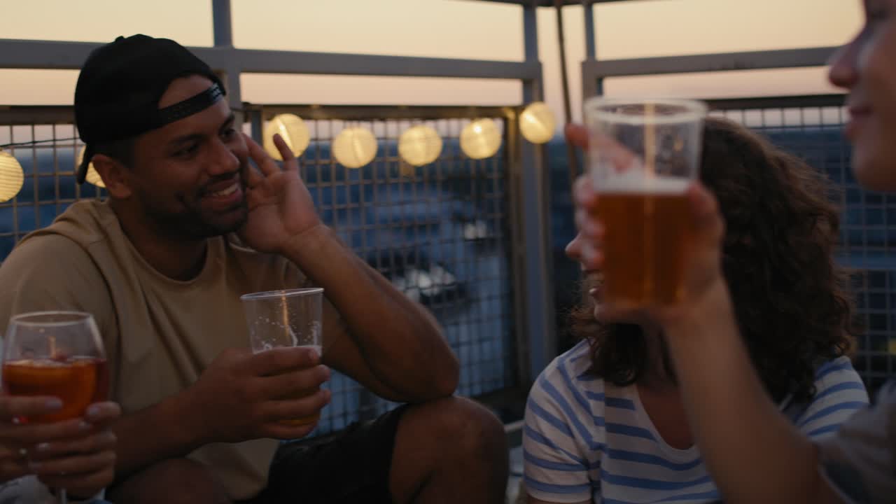 un grupo de amigos se divierten por la noche en la azotea.