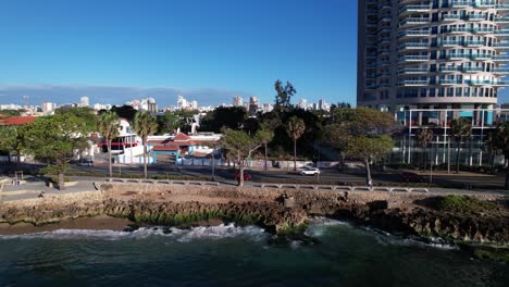 aerial tracking of red car in malecon seafront, santo domingo, dominican republic