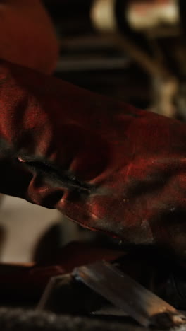 mid-section of welder wearing glove