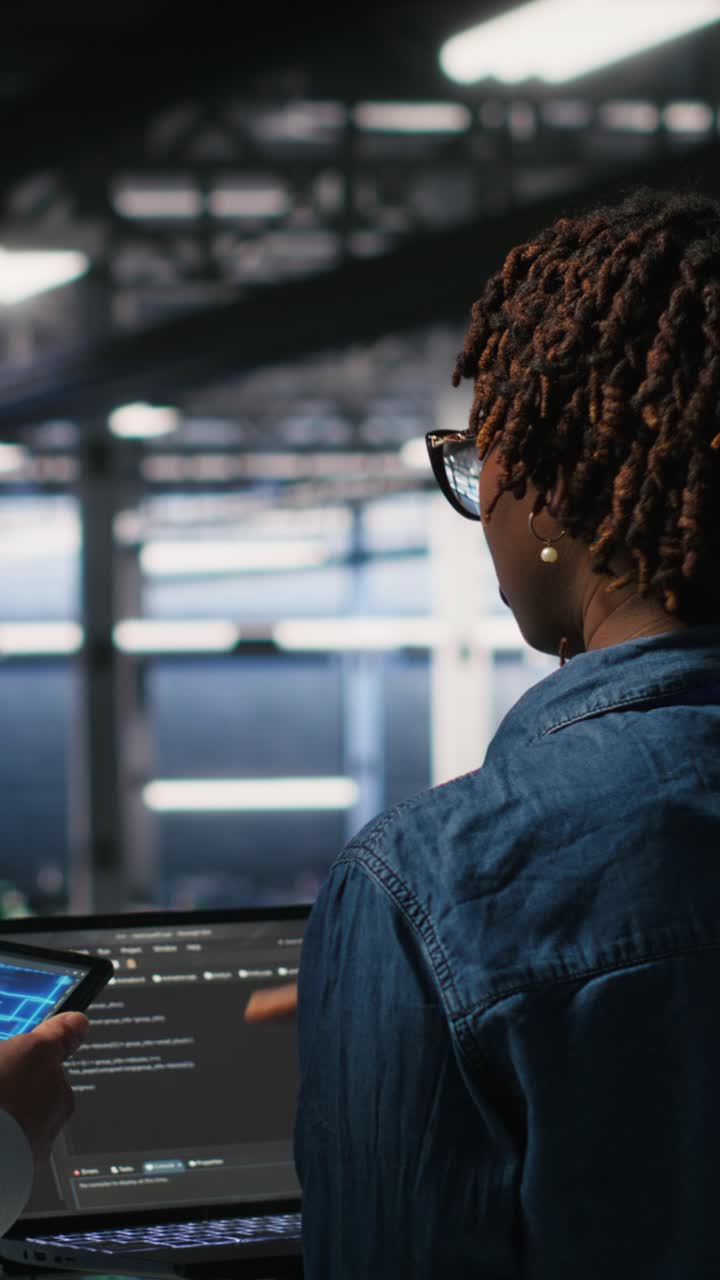 Vertical video Data center system administrators performing maintenance on AI supercomputers