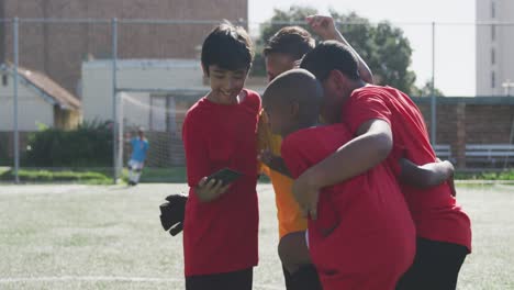 soccer kids in red taking a selfie and laughing in a sunny day