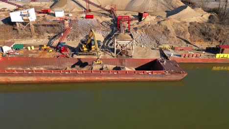 Luftflug-Eines-Baggers,-Der-Sand-Von-Einem-Lastkahn-Auf-Dem-Cumberland-River-In-Clarksville,-Tennessee,-Entlädt