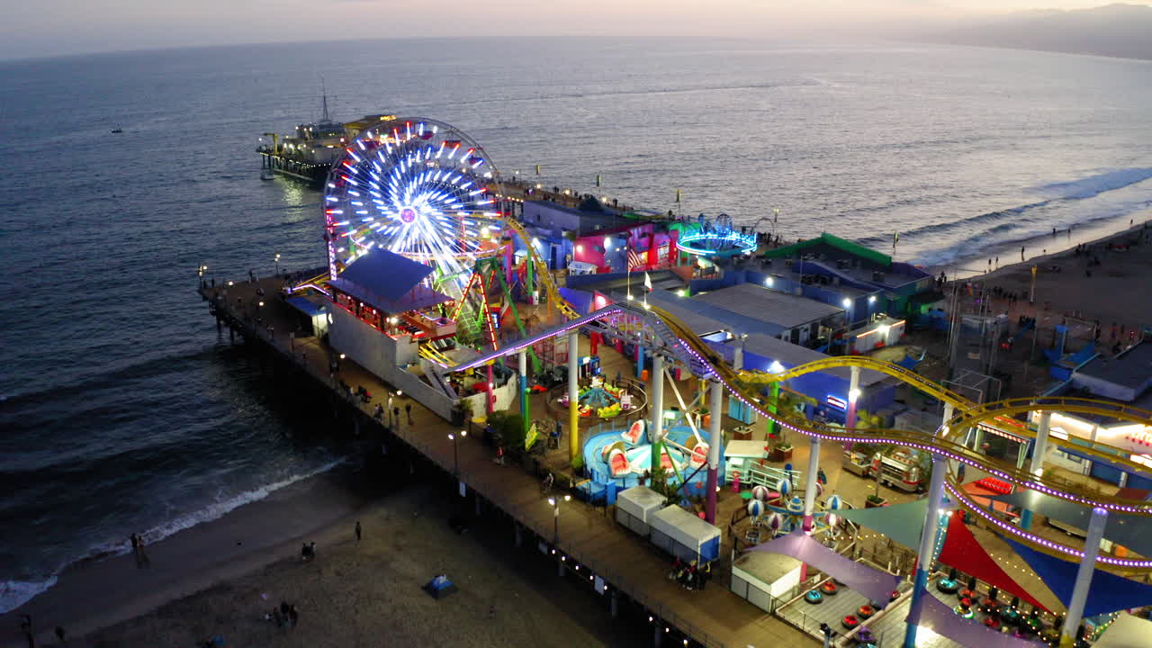 Aerial View of Santa Monica Pier at Dusk with Illuminated Ferris Wheel and Amusement Rides