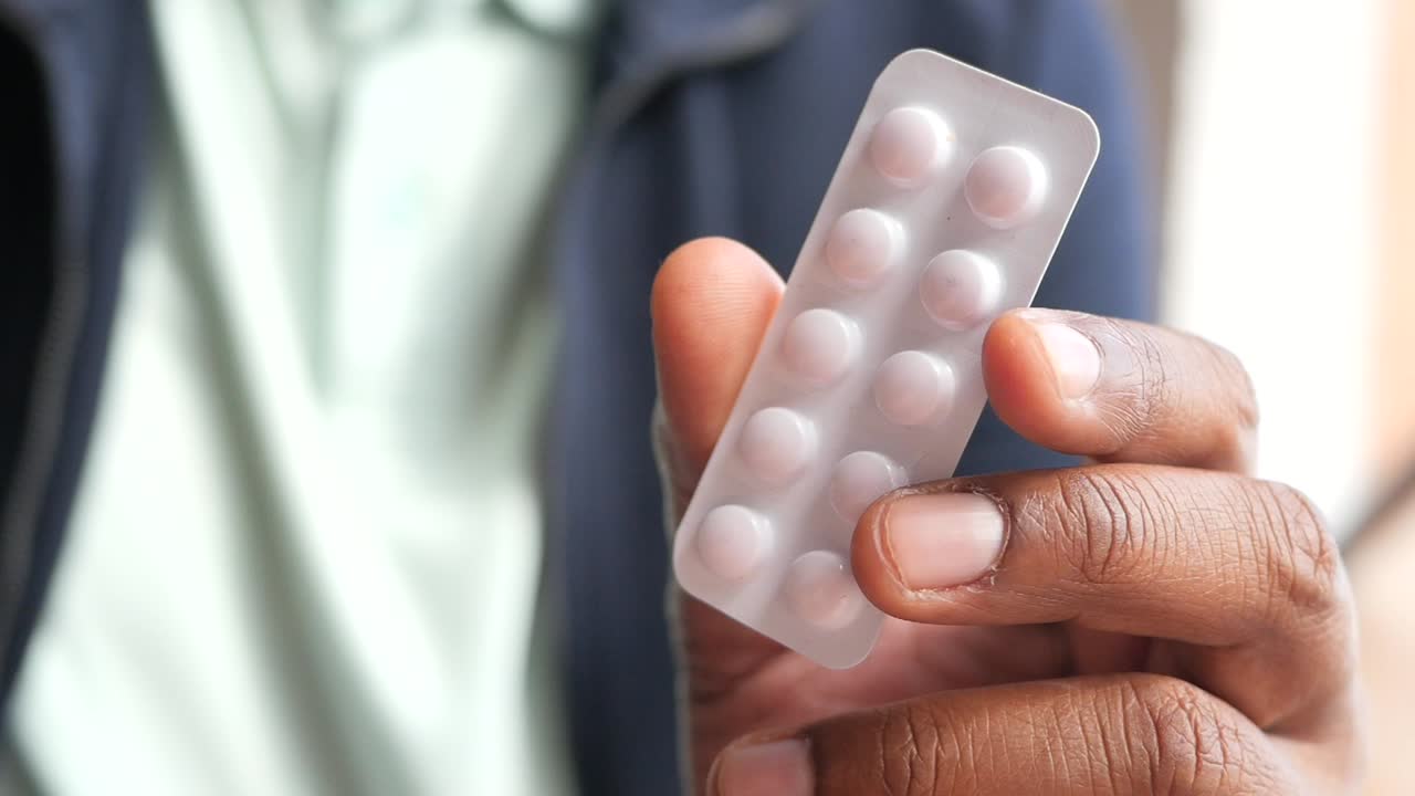 persona que sostiene un blister de pastillas