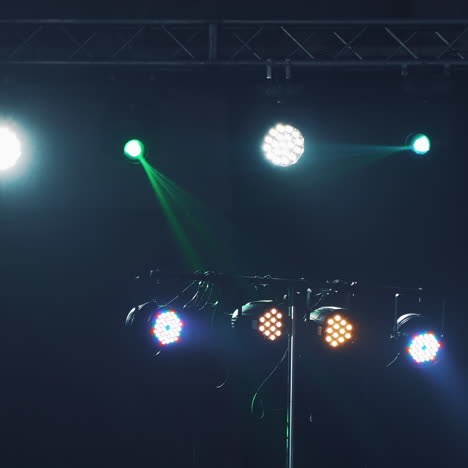 dark stage with colorful spotlights or several bright projectors. different projectors with lighting effects on scene in the evening.