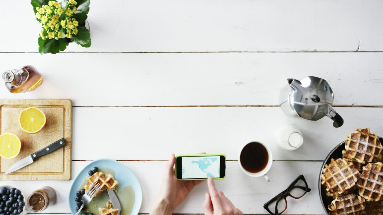 vista superior hombre navegando por el mapa del mundo en la pantalla táctil del teléfono móvil manos en el desayuno desde arriba - dragón épico rojo