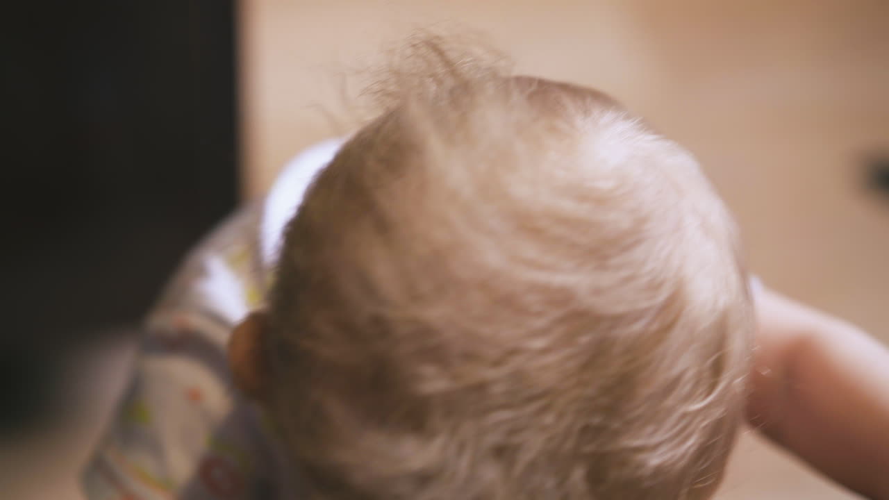 Funny small baby looks with interest at electric light close