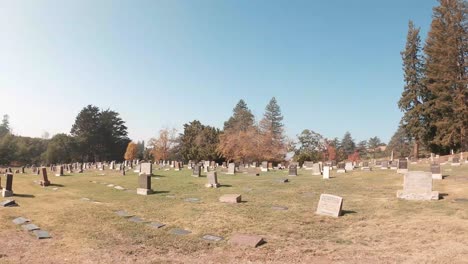 a slow pass across the path of graves and cemetery vase holders during the day.