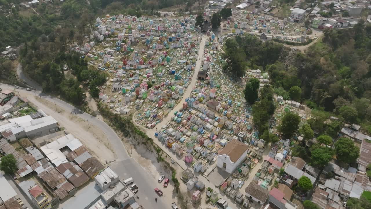 Ampia ripresa aerea con panoramica verso l'alto che rivela il grande cimitero di Chichicastenango, Guatemala.
