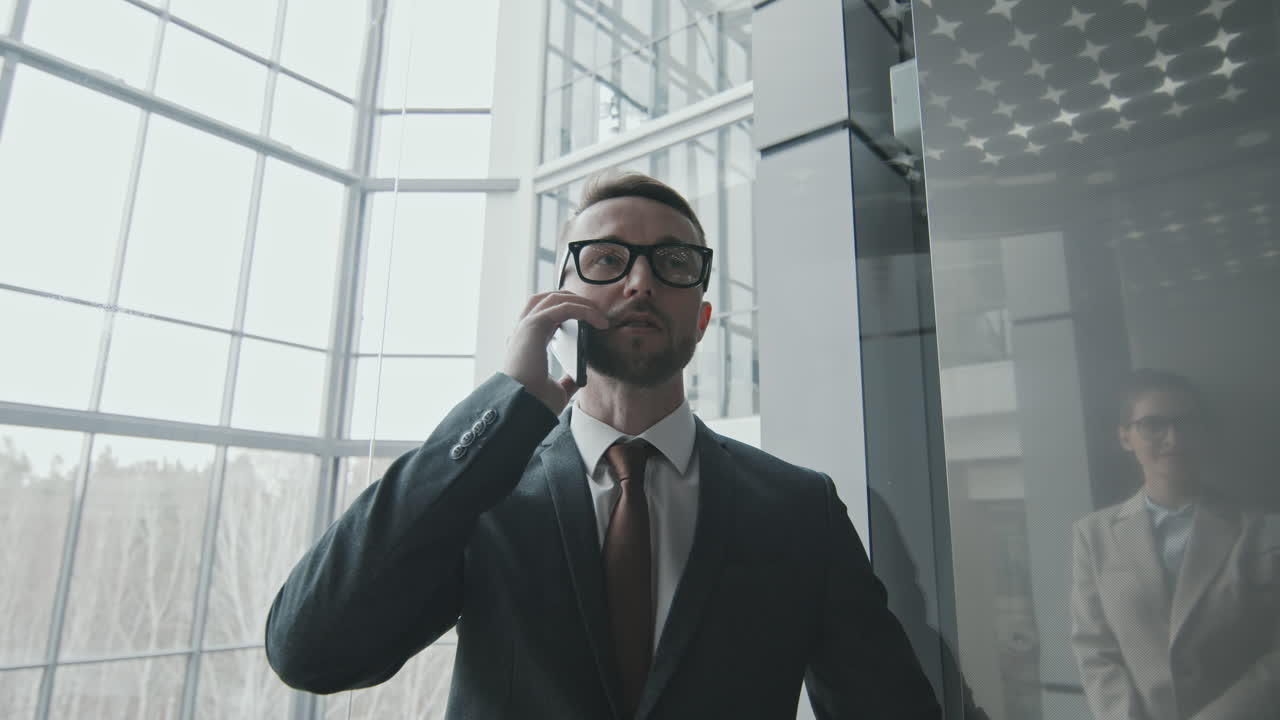 Forretningsmand taler i telefon i elevator