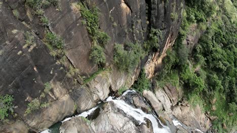 aerial drone over rocky cascades of ravana falls waterfall in ella sri lanka