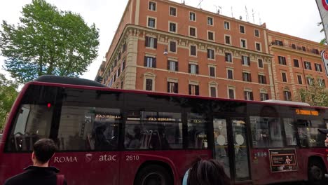 people waiting as bus crosses street