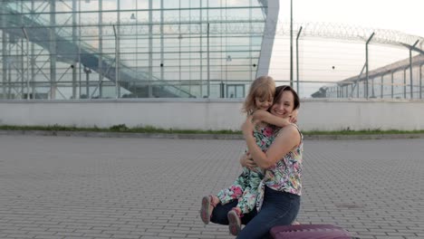 Mother-meet-her-daughter-child-near-airport-terminal-with-open-arms-after-long-flight-vacations-work