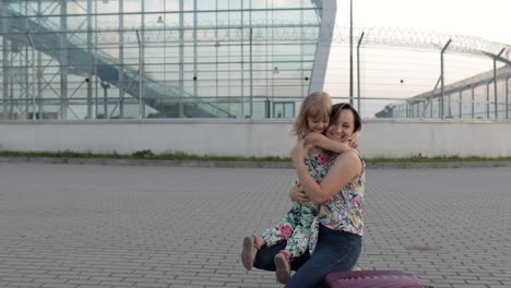 mother meet her daughter child near airport terminal with open arms after long flight vacations work