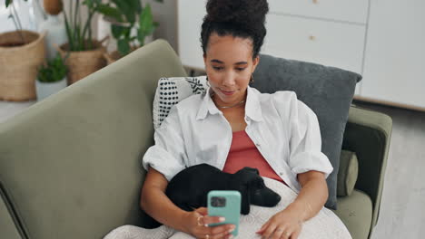 woman relaxing on couch with puppy, using phone