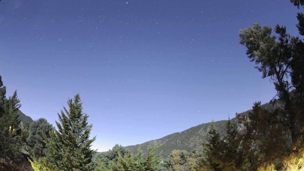 lapso de tempo de trilhas estelares e lua cheia sobre o pine mountain club, califórnia