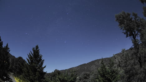lapso de tiempo de rastros de estrellas y puesta de luna llena sobre pine mountain club california