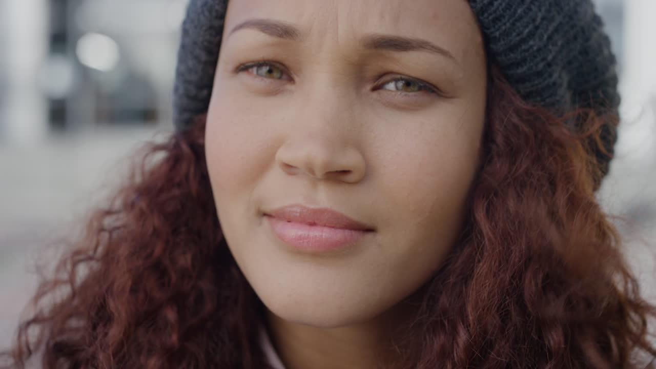 retrato de cerca hermosa joven de raza mixta mujer gira la cabeza buscando confianza calma independiente mujer con sombrero de gorra viento soplando el cabello cámara lenta